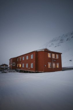 Gjestehuset hostel kahverengi binası sisli kutup gününde Longyear, Svalbard 'da