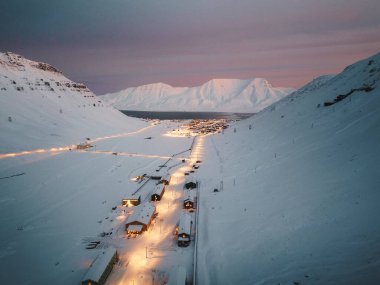 Longyearbyen, Svalbard 'ın Kuzey Kutbu kışında pembe gün batımında insansız hava aracı çekimi