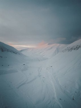 Drone shot of snowy valley at sunset in the arctic outside Longyearbyen Svalbard clipart