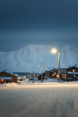 Longyearbyen Svalbard kasabası kışın karlı fiyort ve arktik dağın önünde