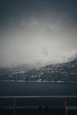 Kuzey Kutbu Norveç 'teki Lyngen Alpleri' ndeki karlı dağların üzerinde yoğun sis var.