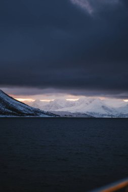 Kuzey Kutbu Norveç 'teki Lyngen Alplerinde gri bulutların altındaki dağlar