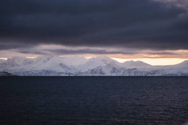 Kuzey Norveç 'te kışın gün batımında Kuzey Buz Denizi kıyısındaki dağlar