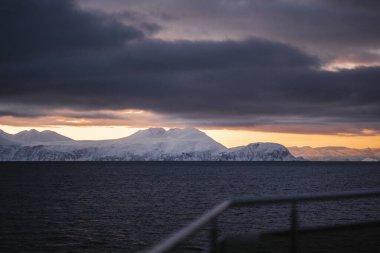 Kuzey Norveç 'te kışın gün batımında Kuzey Buz Denizi kıyısındaki dağlar