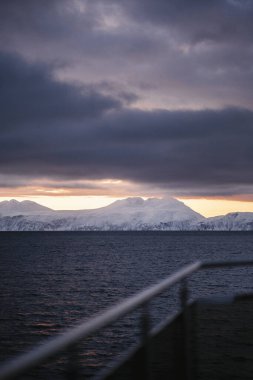 Kışın bulutlu günbatımında dağlar, Kuzey Norveç 'teki Lyngen Alpleri