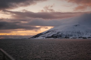 Kuzey Norveç 'te bulutların altındaki karlı dağlar, Lyngen Alpleri