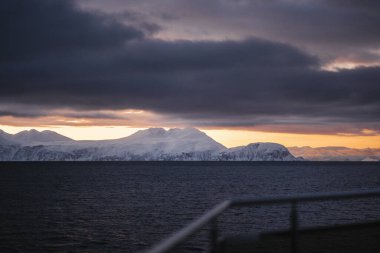 Kuzey Norveç 'te kışın gün batımında Kuzey Buz Denizi kıyısındaki dağlar