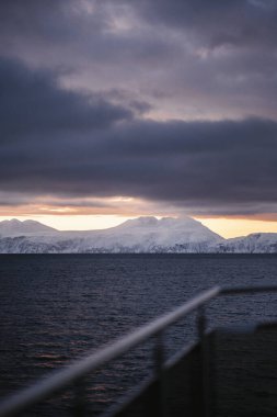 Kışın bulutlu günbatımında dağlar, Kuzey Norveç 'teki Lyngen Alpleri