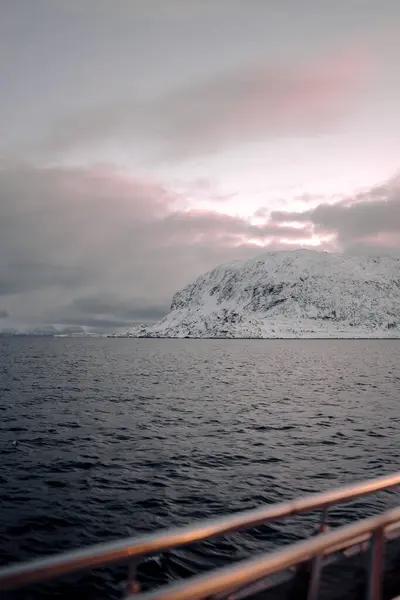 Kuzey Norveç 'te kış mevsiminde Arktik okyanus kıyısındaki Lyngen Alp Dağları üzerinde pembe gökyüzü