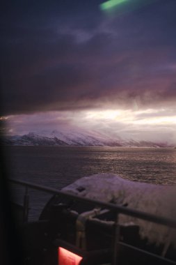 Norveç 'in Lyngen Alpleri' ndeki Arktik dağları arasındaki fiyort üzerinde kış günbatımı manzarası