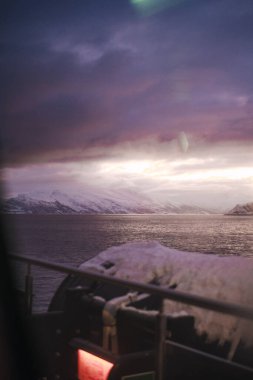 Norveç 'in Lyngen Alpleri' ndeki Arktik dağları arasındaki fiyort üzerinde gün batımı manzarası