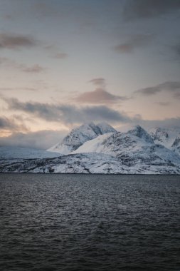 Kuzey Norveç 'te kış günbatımında Lyngen Alpleri karla kaplıydı.