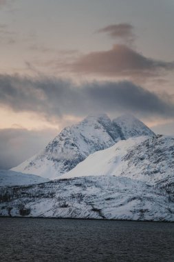 Karlı Lyngen Alp Dağları bulutların altında, Kuzey Arktik Norveç 'te günbatımı
