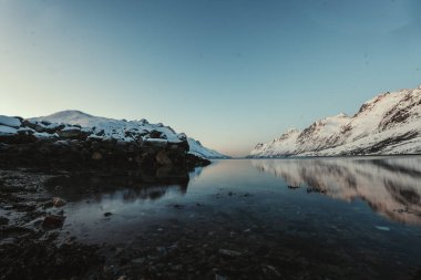 Arktik okyanus ve kışın Norveç, Tromso yakınlarındaki Ersfjord 'da yansıyan dağlar..