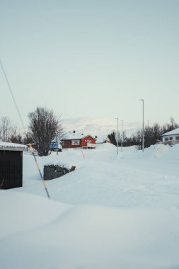 Güneşli kış gününde Ersfjordbotn 'daki karlı yerleşim bölgesi Tromso Norveç.