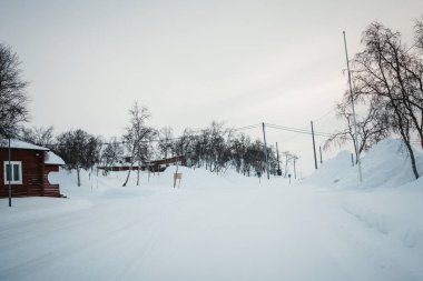 Finlandiya 'nın Kilpisjarvi şehrinde kışın yürüyüş merkezinde karlı bir otopark.