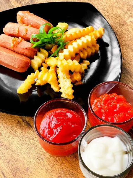 Sosis ve soslu patates kızartması.