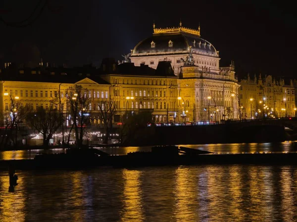 Büyülü gece Prag. Vltava Nehri 'nin setini kaplayan tarihi evler ve Ulusal Tiyatro