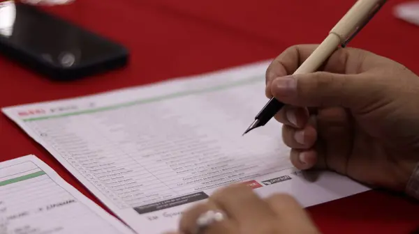 Kalemle bir listeye el yazısının yakın plan çekimi. Not alma, organize etme ve planlama eylemi.