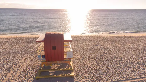 Miami Beach, Florida boyunca klasik bir sahil kulübesinin havadan görünüşü büyüleyici tasarımını canlı sahil şehrinin arka planına karşı sergiliyor. Tropikal bir tatil deneyimi için mükemmel.