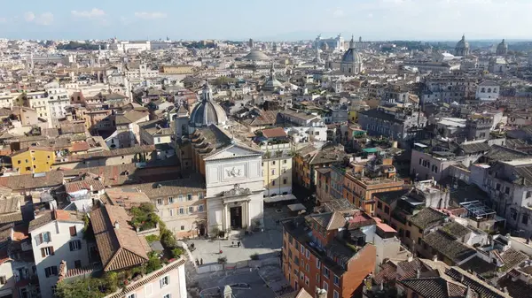 Roma, İtalya 'nın göbeğindeki güzel bir kilisenin havadan görünüşü, canlı şehir manzarası arasında mimarisini sergiliyor, tarihi kent merkezinin çarpıcı bir perspektifini sunuyor.