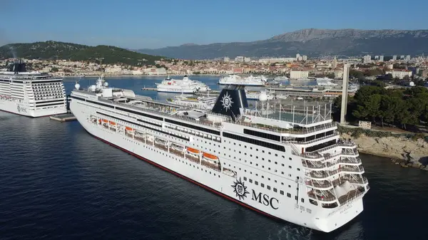 İtalya 'nın Venedik kentinde kenetlenmiş MSC Sinfonia yolcu gemisinin fotoğrafı, arka planda ikonik şehir manzarası ve Venedik lagünü olan lüks gemiyi gösteriyor ve mükemmel bir seyahat deneyimi sunuyor..