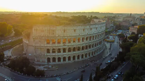 Roma, İtalya 'daki Colosseum' un çarpıcı günbatımı manzarası, antik harabeleri aydınlatan sıcak altın ışıkla. Fotoğraf, Roma 'nın kalbinde akşam saatlerinde sembolik simgeleri yakalıyor.