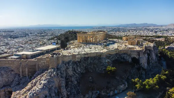 Yunanistan 'ın Atina kentindeki Partenon ve Akropolis' in havadan görünüşü, antik kalıntıları kentin arka planına karşı sergiliyor. Fotoğraf, bu ikonik alanın tarihsel önemini ve güzelliğini yansıtıyor.