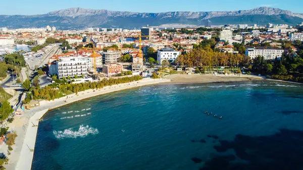 Hırvatistan 'ın Split kentindeki Bacvice Plajı. Turkuvaz suları, güneş banyosu, yüzücüler ve çarpıcı Akdeniz manzarasıyla çevrili güzel kumlu kıyı şeridi..