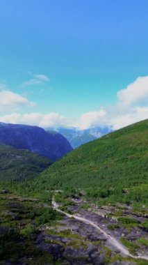 Bereketli yeşillikler ve görkemli uzak tepelerle çevrili engin dağ vadisinin muhteşem manzarasının tadını çıkar.