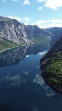 Huzurlu fiyort, el değmemiş temiz gökyüzünün altındaki görkemli uçurumları ve yemyeşil yeşillikleri güzel yansıtır.