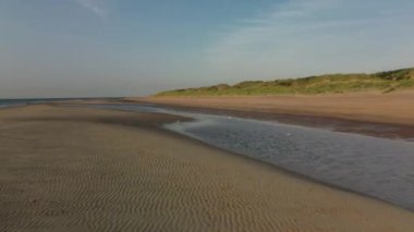 Sakin sularla sakin bir sahil manzarası, rahatlama ve doğa takdiri için mükemmel, ideal bir ortam yaratır.