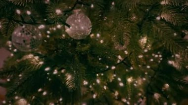 Renkli ışıkları ve parlak süslemeleri olan güzel dekore edilmiş bir Noel ağacı Noel ruhunu yakalıyor.