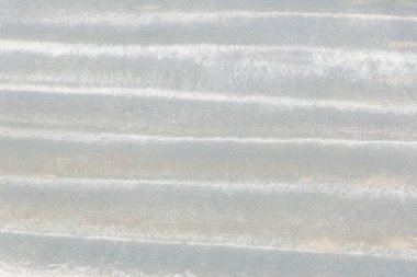 Yatay çizgili beyaz kumsaldaki dalga desenlerinin fotoğrafı, yakın çekim makroda çekilmiş bir fotoğraf. Grafik bir kaynak, yaratıcı tasarım, yüzeyler ve altyapılar. Yatay.