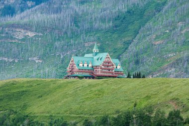 Waterton Lakes Ulusal Parkı, Kanada 'daki Galler Prensi Oteli. Otel, arkasında dağlar olan güzel yeşil bir manzaranın merkezinde çekilmiştir..