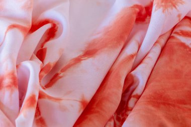 Güzel turuncu, şeftali ve buruşuk ipek kumaşta beyaz kravat boyası deseni. Grafik kaynakları, yaratıcı tasarım, yüzeyler ve arka planlarda kullanmak için fotoğraflanmış yakın plan.