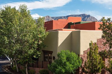 Sedona, Arizona, ABD 'de mavi gökyüzü ve kabarık beyaz bulutlar arasında renkli bir bina..