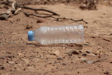 Yerde duran plastik bir şişenin yakın çekimi.