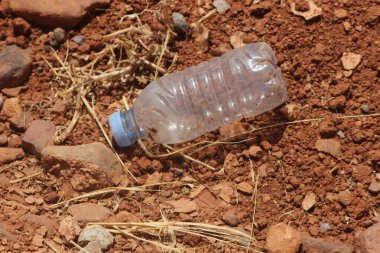 Yerde duran plastik bir şişenin yakın çekimi.