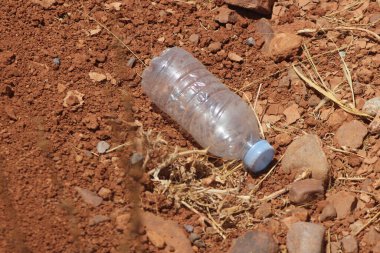 Yerde duran plastik bir şişenin yakın çekimi.