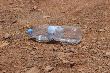 Yerde duran plastik bir şişenin yakın çekimi.