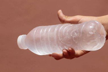 Elin bir şişe donmuş suyu tutuyor.