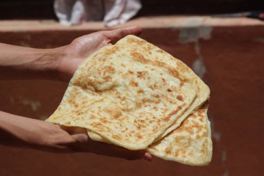 Msemmen ya da Msemen olarak bilinen geleneksel Fas ekmeğini tutan eller.