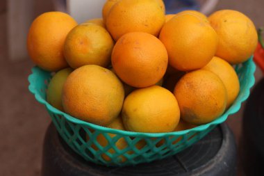 Portakal dolu plastik bir sepet.