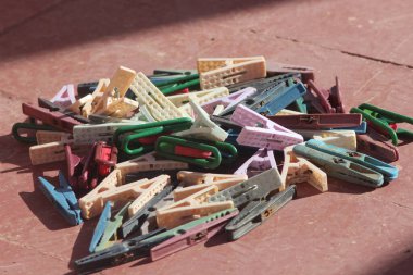 Colorful plastic clothespins on a reddish-brown surface