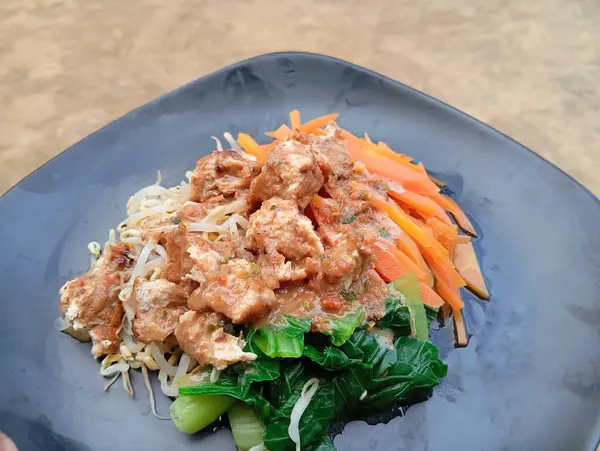 stock image called pecel sayur, consisting of green vegetables, bean sprouts and carrots with peanut sauce as a complement