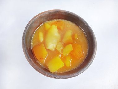 Tatlı patates kompostosu ya da beyaz arka planda toprak bir kasede kolak ubi.