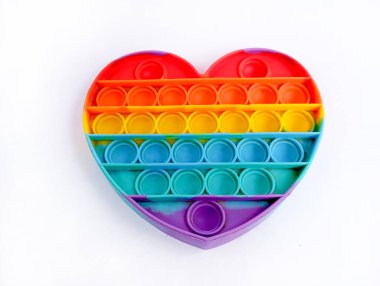 Gökkuşağı renkli. Beyaz bir arka planda izole edilmiş kalp şeklinde bir oyuncak.