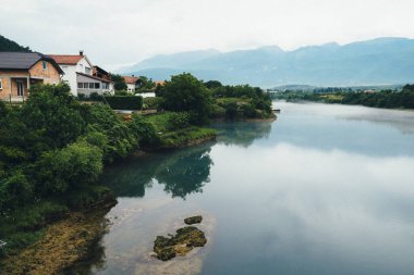 Huzurlu bir manzara, Bosna-Hersek 'in Mostar kentindeki sakin nehir ve dağları şafakta yansıtıyor..