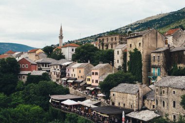 Bosna-Hersek 'in tarihi Mostar kentinde dolambaçlı nehir boyunca inşa edilmiş büyüleyici binalar ve canlı açık hava kafeler yer alıyor..